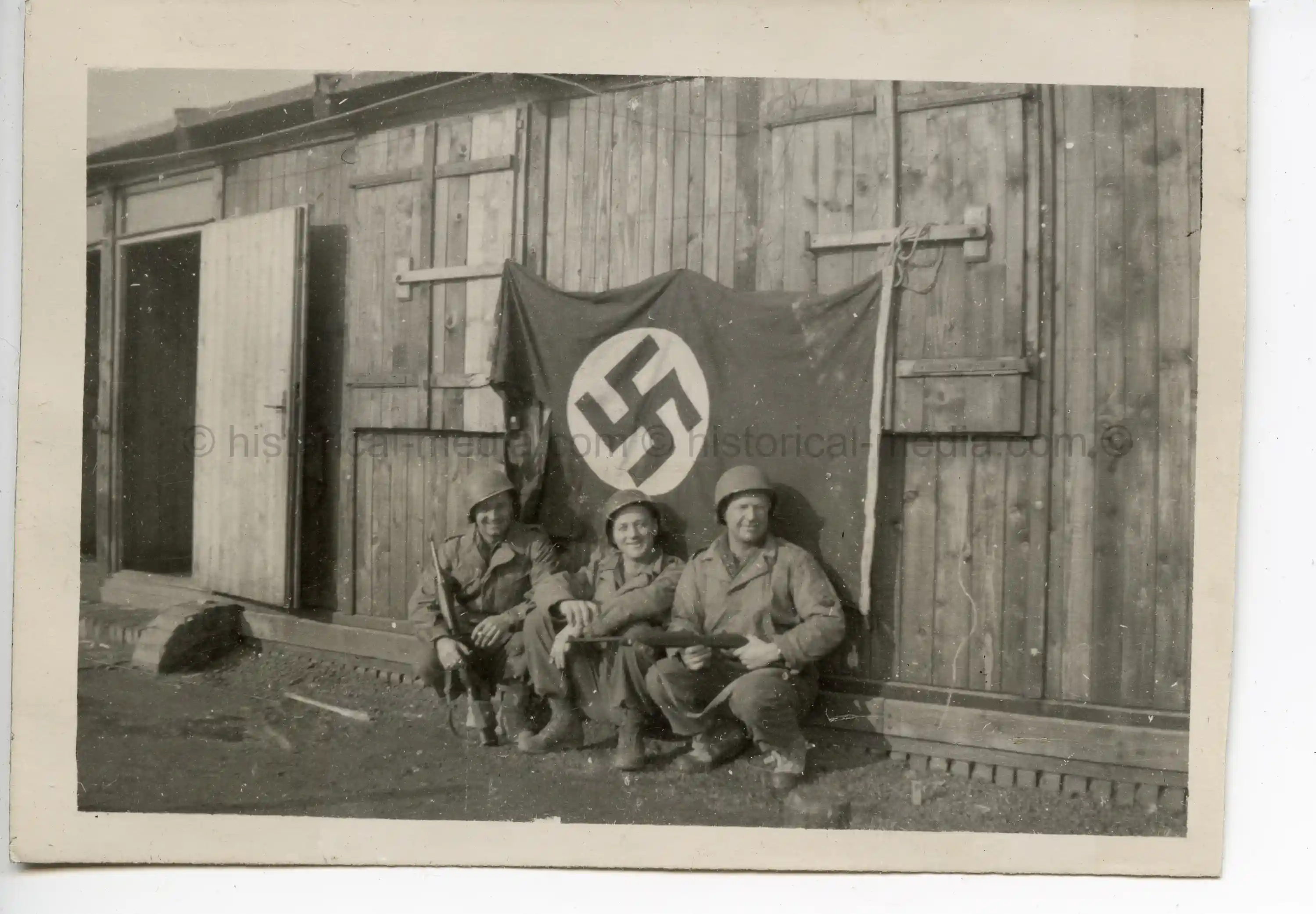 USGI PHOTOS - SOLDIERS POSE W/ CAPTURED GERMAN FLAG - FEB. 1945