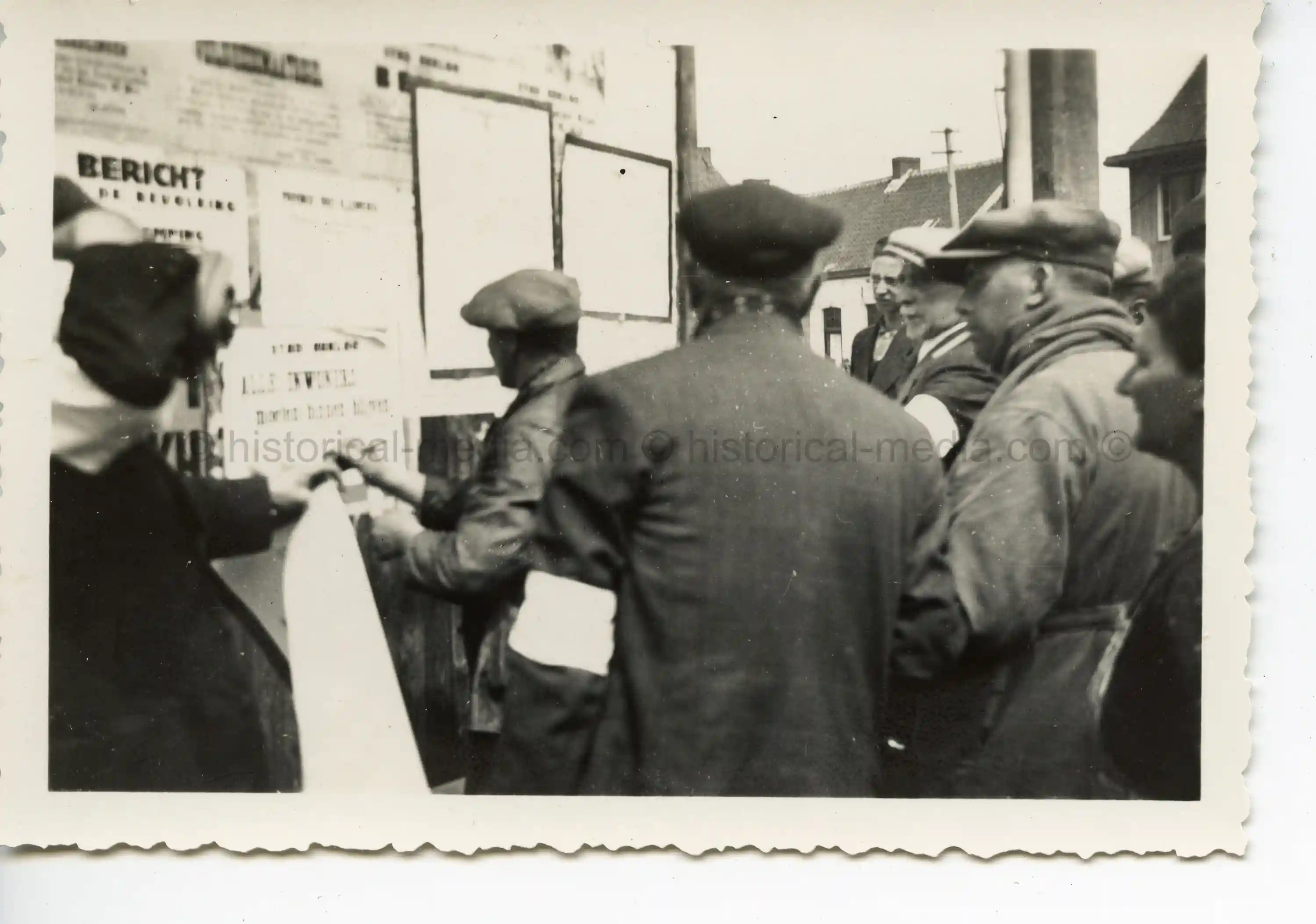 GERMAN PHOTO OF JEWS IN WARSAW WEARING ARMBANDS READING POSTED NOTICES