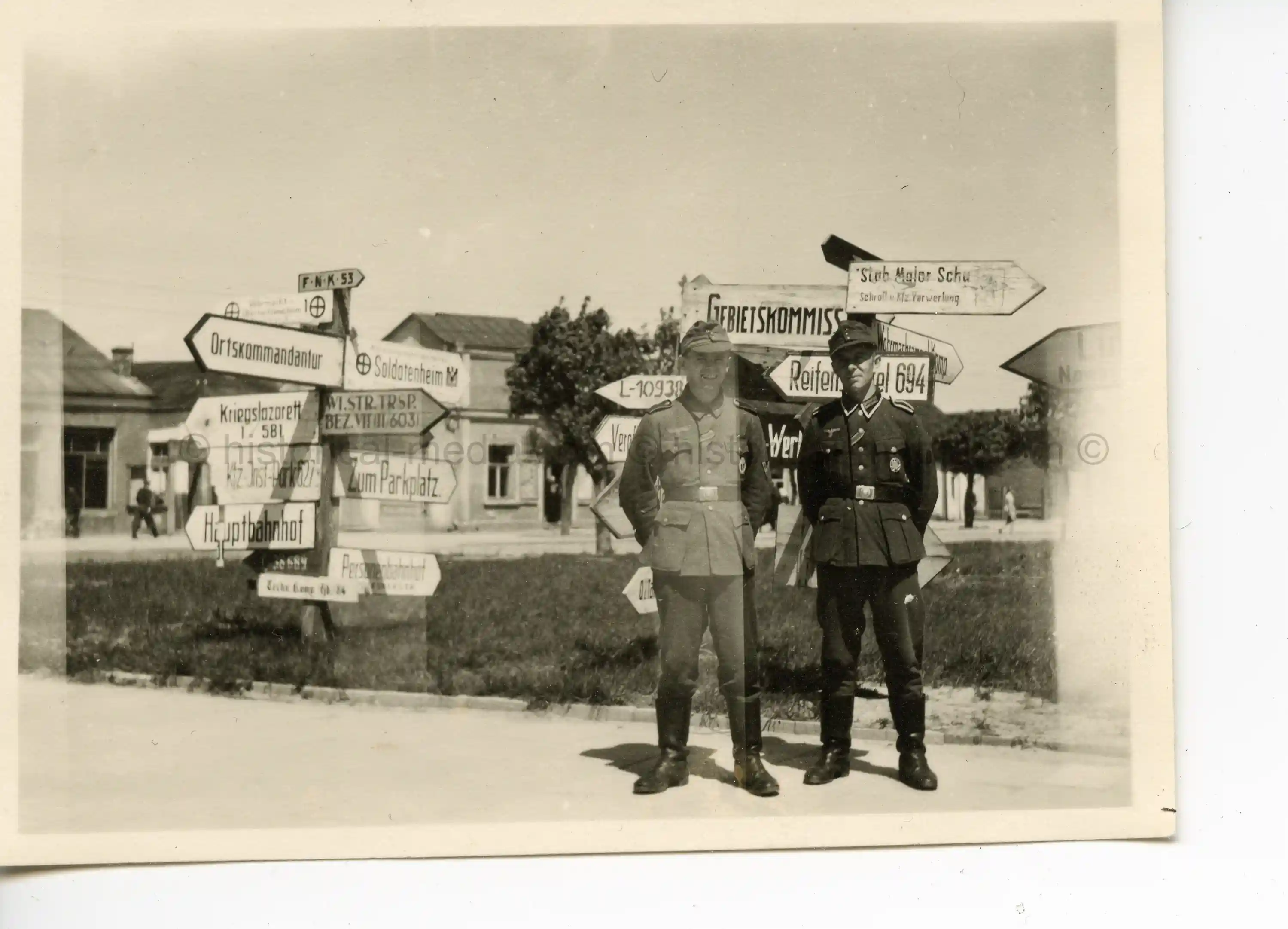 PHOTO OF GERMAN SOLDIERS POSING BY ROAD SIGN 